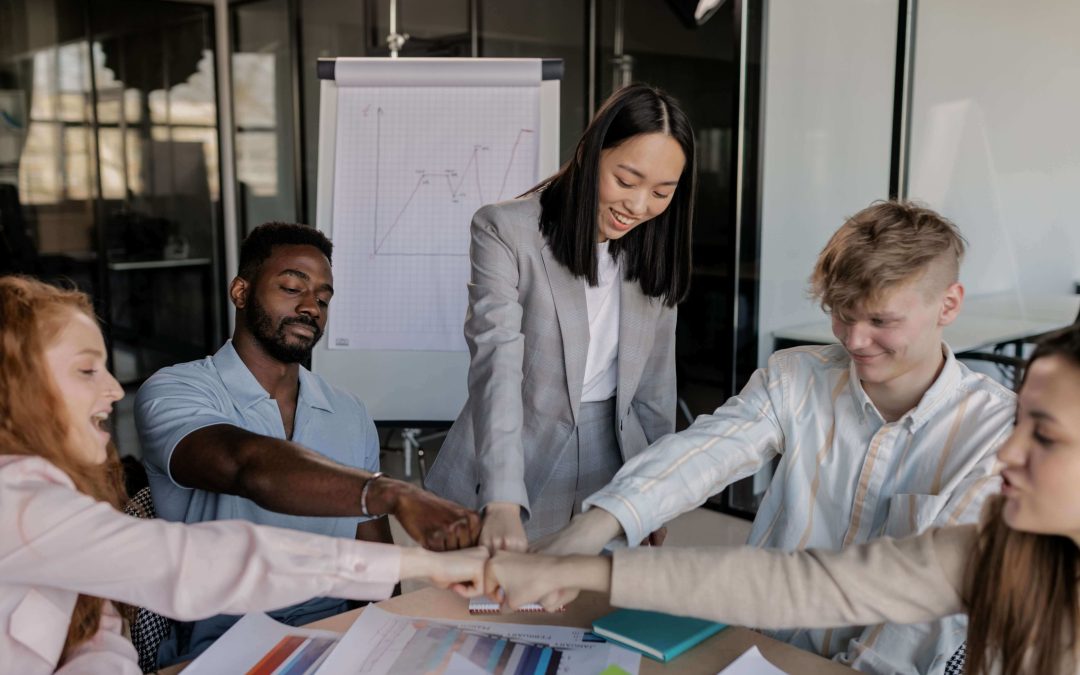 Alt=Five professionals shaking hands across a table.