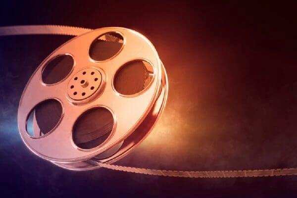 Film reel with unwound strip symbolizing cinema and storytelling