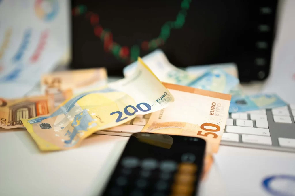 Foreign Exchange & Currency Trading Insights – PSP Languages Euro banknotes with calculator and financial market chart for forex trading and investment analysis