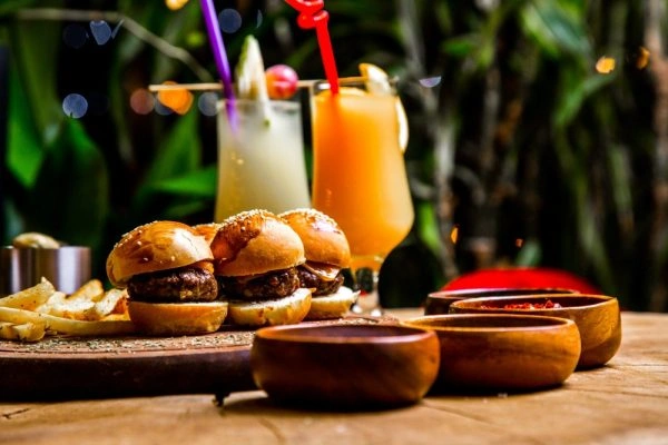 Mini burgers with fries and drinks on wooden table
