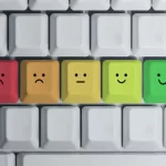 Keyboard keys with colored faces showing emotions from sad to happy