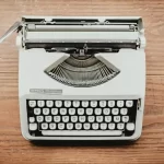 Vintage white typewriter placed on a wooden desk, symbolizing writing, blogging, content creation, and storytelling.